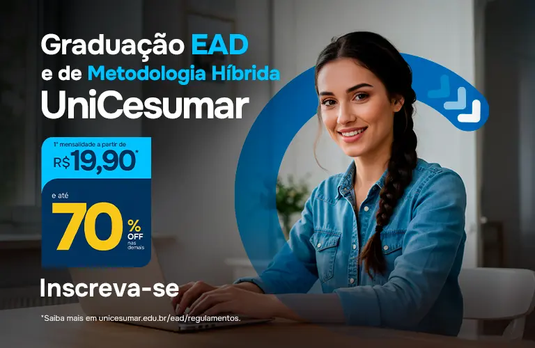 Mulher branca de cabelos escuros e longos feito trança, vestindo uma blusa jeans azul claro assistindo aula pelo computador.